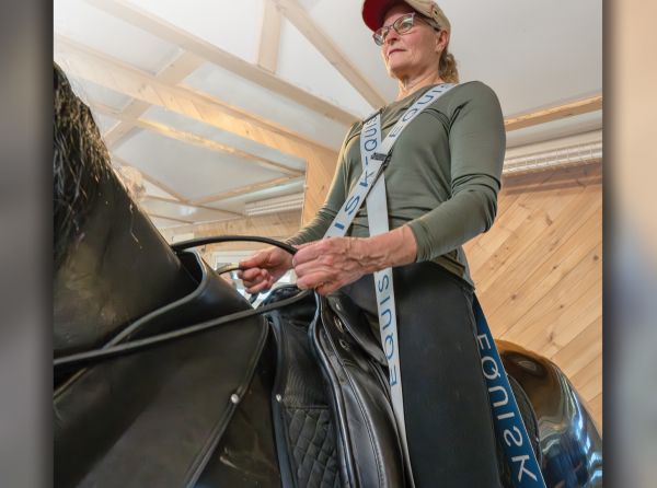 Rider using Equisk resistance bands on RooElla horse simulator to improve stability, posture, and equestrian biomechanics.